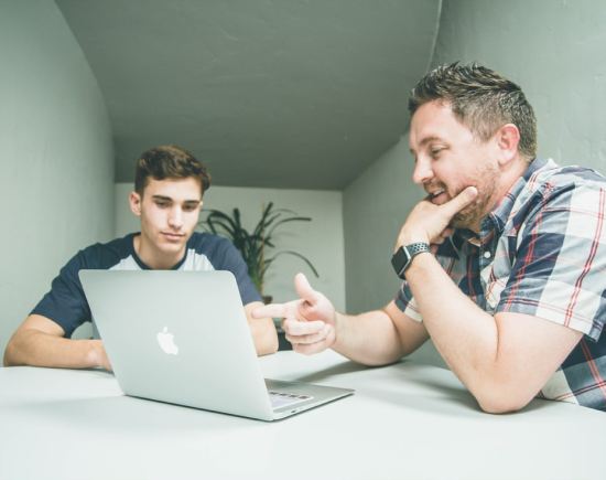 A mentor and a student working together on a laptop