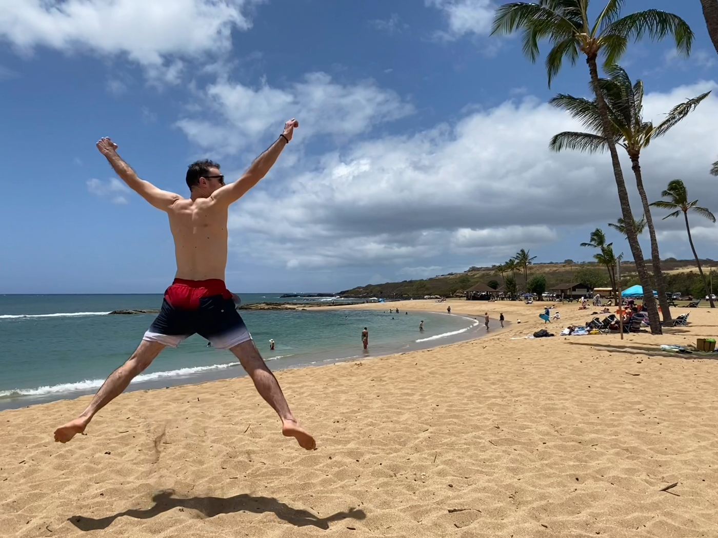 Rob jumping for joy on a tropical beach